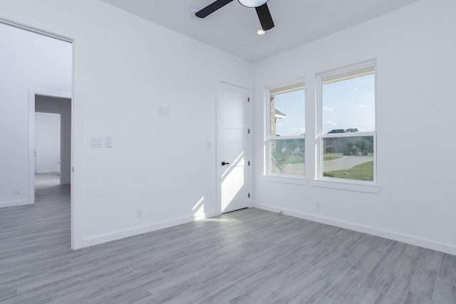 empty room with ceiling fan and light wood-type flooring