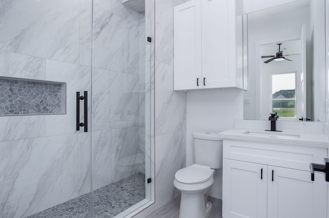 bathroom featuring vanity, ceiling fan, toilet, and walk in shower