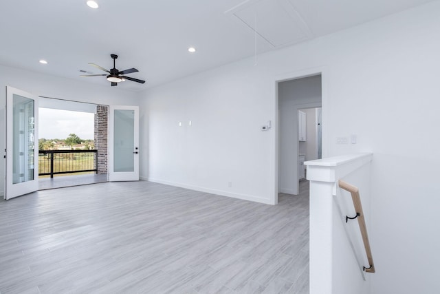 empty room with ceiling fan, french doors, and light wood-type flooring