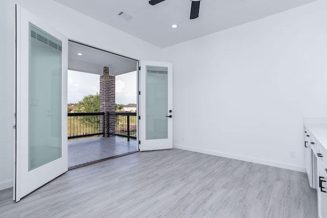 empty room with french doors, light hardwood / wood-style flooring, and ceiling fan