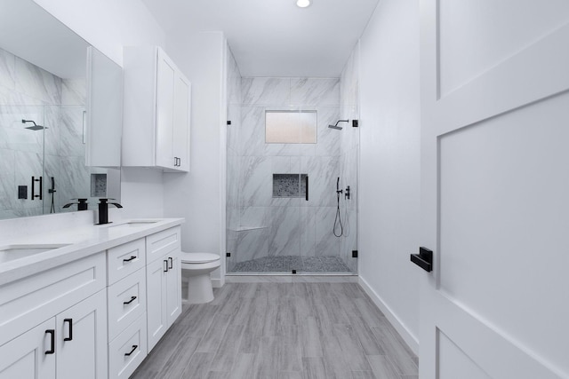 bathroom featuring toilet, a shower with door, vanity, and hardwood / wood-style flooring