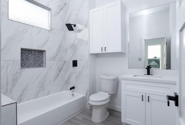 full bathroom featuring wood-type flooring, vanity, toilet, and tiled shower / bath combo