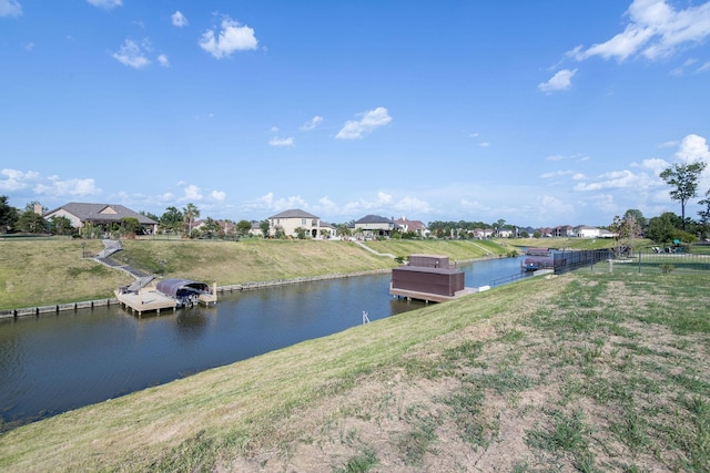 dock area with a lawn and a water view