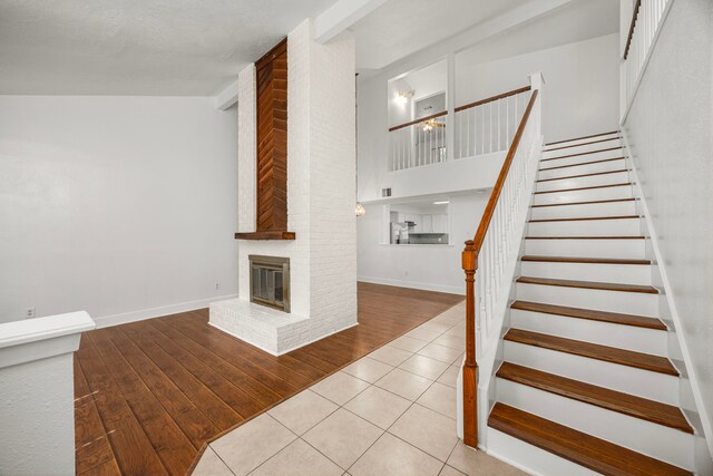 interior space with light hardwood / wood-style flooring, vaulted ceiling, and a brick fireplace