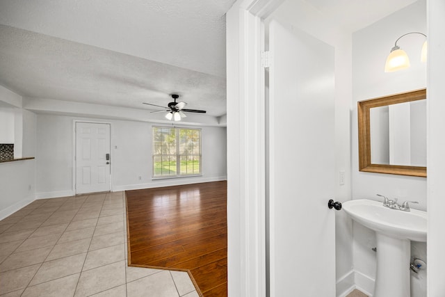 bathroom featuring ceiling fan, sink, wood-type flooring, and a textured ceiling