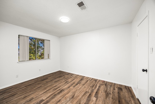 spare room with dark hardwood / wood-style flooring and a textured ceiling