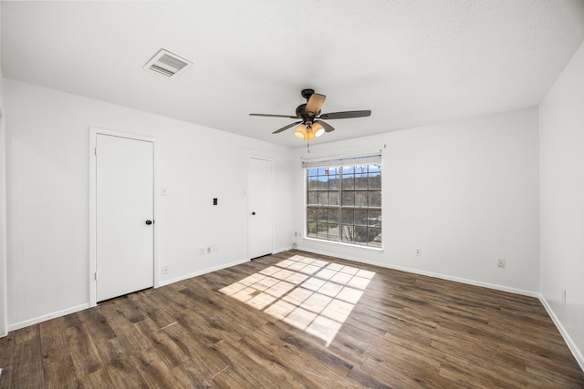 spare room featuring ceiling fan and dark wood-type flooring