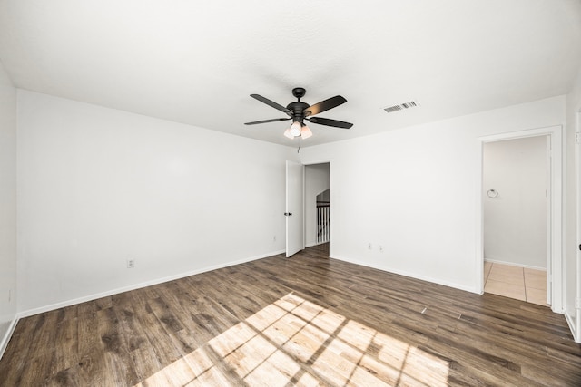 spare room featuring ceiling fan and dark wood-type flooring