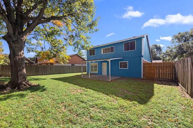 rear view of house with a patio and a lawn