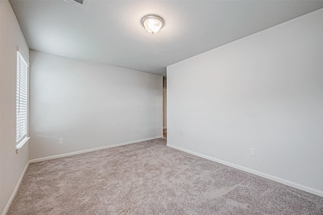 unfurnished room featuring light carpet