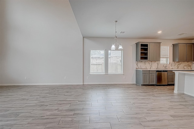 kitchen with decorative backsplash, pendant lighting, and a notable chandelier