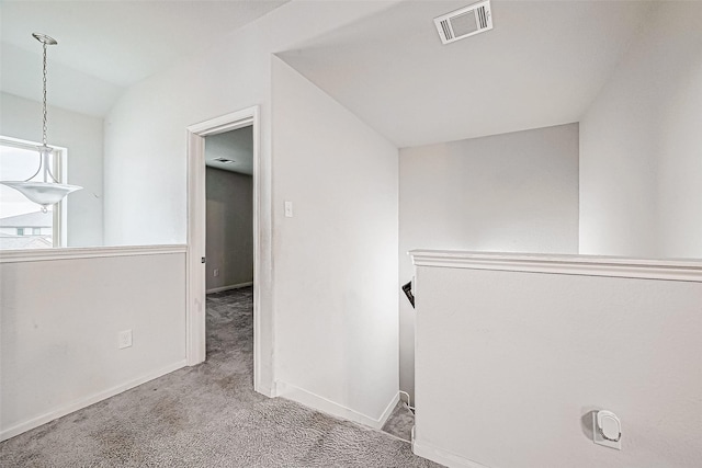 hall featuring light colored carpet and vaulted ceiling