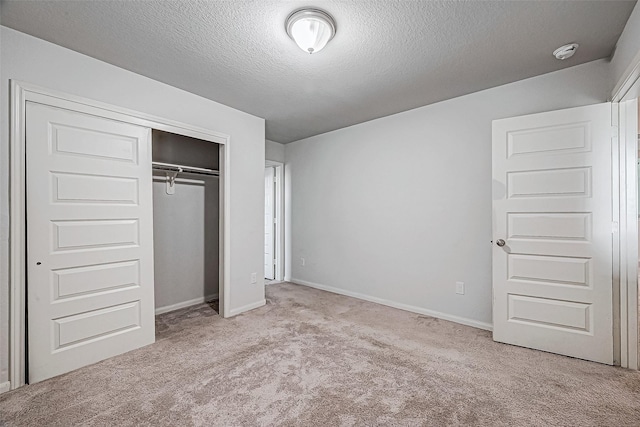 unfurnished bedroom with a textured ceiling, light colored carpet, and a closet