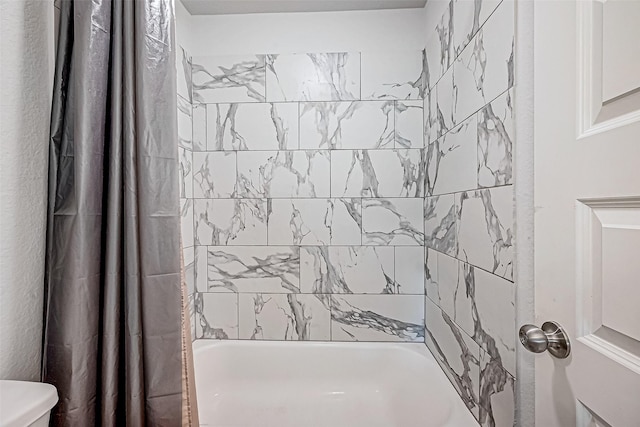 bathroom featuring shower / tub combo and toilet