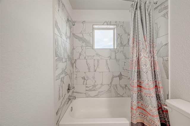 bathroom with shower / tub combo and toilet