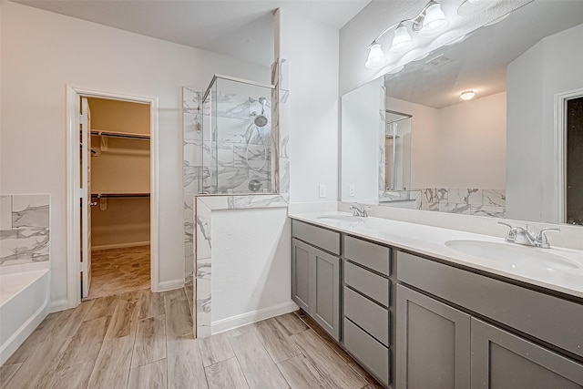 bathroom with vanity, wood-type flooring, and independent shower and bath