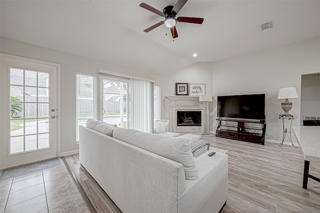 living room featuring ceiling fan, light hardwood / wood-style floors, and vaulted ceiling