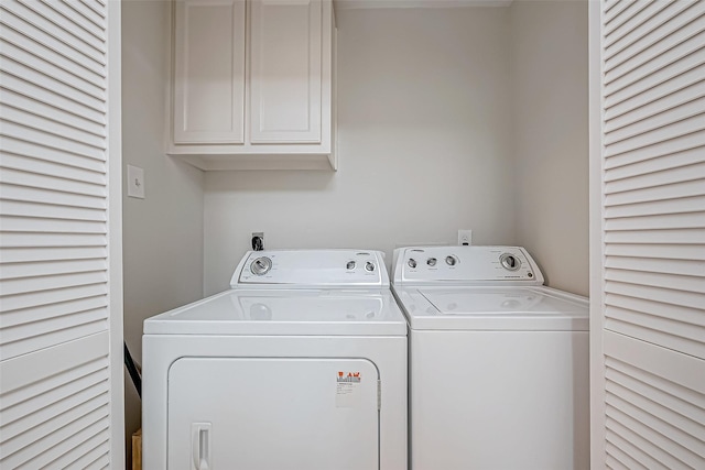 washroom with washer and dryer and cabinets