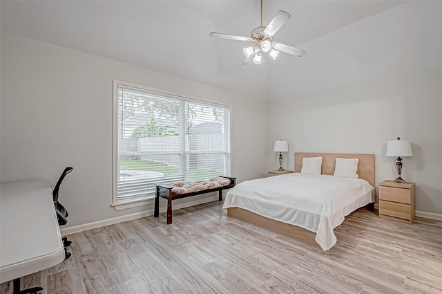 bedroom with ceiling fan, light hardwood / wood-style floors, and lofted ceiling