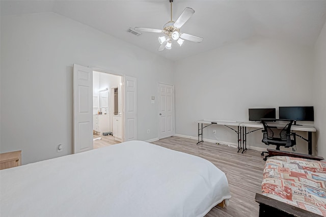 bedroom featuring ceiling fan, ensuite bathroom, lofted ceiling, and light wood-type flooring