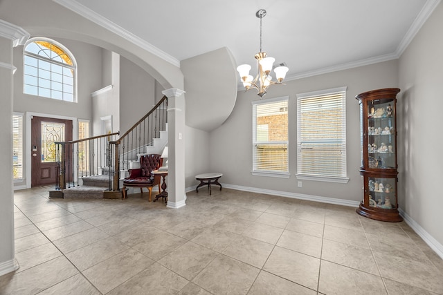 foyer featuring ornate columns, ornamental molding, light tile patterned floors, and an inviting chandelier