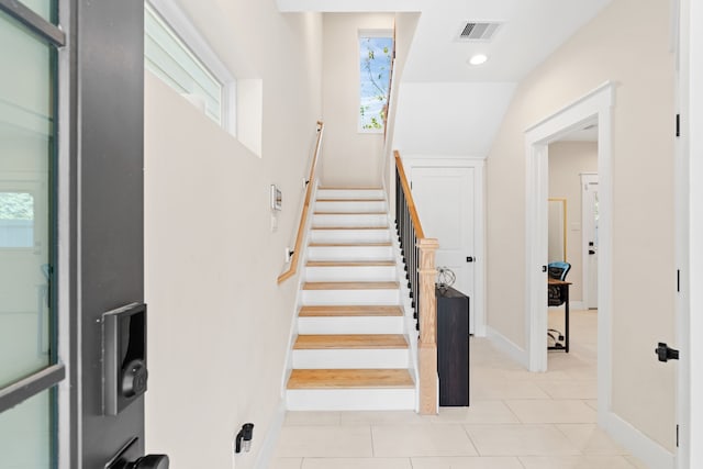 stairway featuring tile patterned flooring and a wealth of natural light