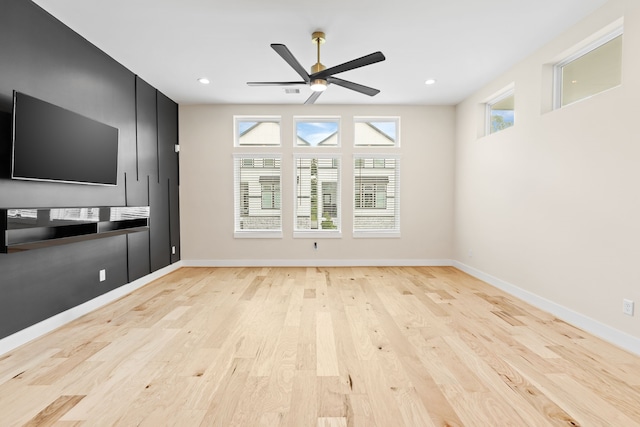 unfurnished living room with ceiling fan and light wood-type flooring