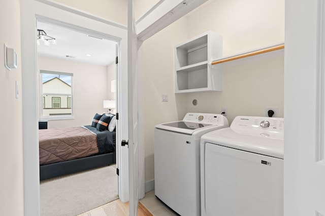 clothes washing area featuring washing machine and dryer and light colored carpet