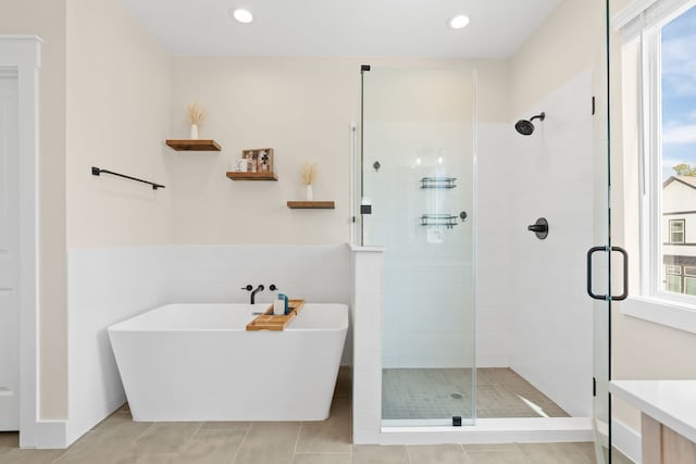 bathroom with tile patterned flooring and separate shower and tub