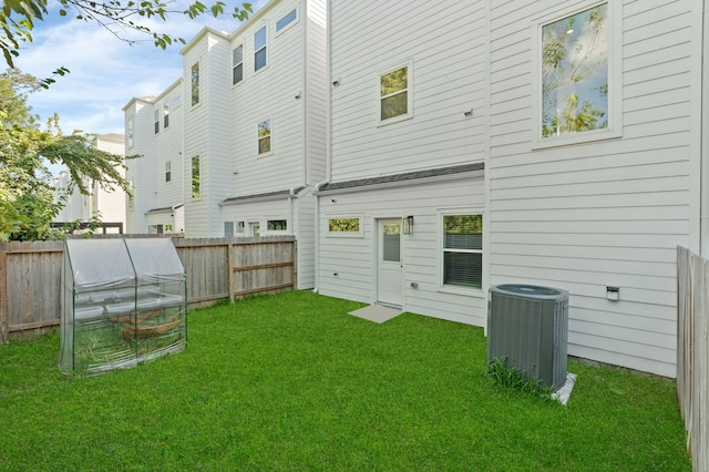 back of house featuring an outdoor structure, a lawn, and central AC unit