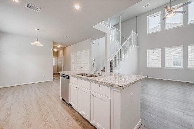 kitchen featuring dishwasher, sink, white cabinets, and light hardwood / wood-style floors