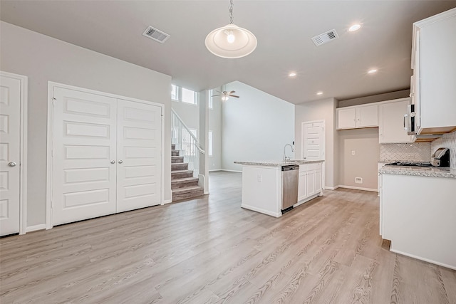 kitchen with stainless steel appliances, ceiling fan, light hardwood / wood-style floors, white cabinetry, and hanging light fixtures