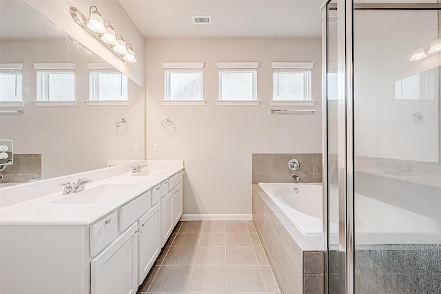 bathroom featuring vanity, tiled bath, and tile patterned floors