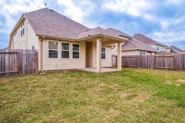 rear view of house with a yard and a patio