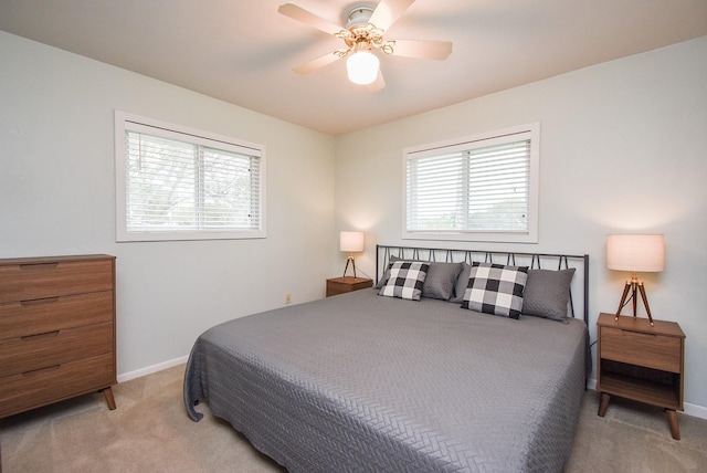 bedroom featuring multiple windows, ceiling fan, and light carpet