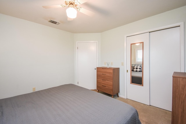 bedroom with ceiling fan, a closet, and light carpet