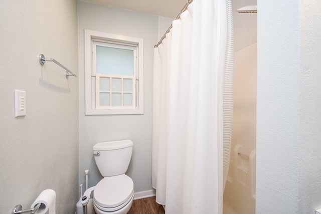 bathroom featuring hardwood / wood-style flooring, toilet, and a shower with shower curtain