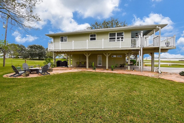 rear view of house featuring a patio, a yard, a fire pit, and a wooden deck