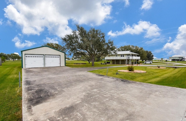 view of front of house featuring a garage, an outdoor structure, and a front yard