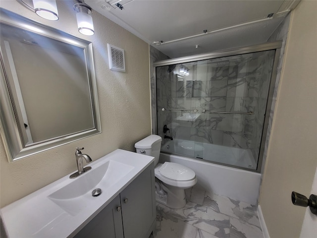 bathroom featuring marble finish floor, a textured wall, toilet, enclosed tub / shower combo, and vanity