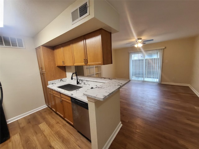 kitchen featuring a peninsula, visible vents, open floor plan, and a sink