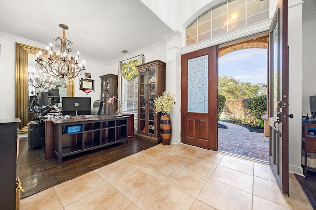 foyer featuring a chandelier, light tile patterned floors, and crown molding