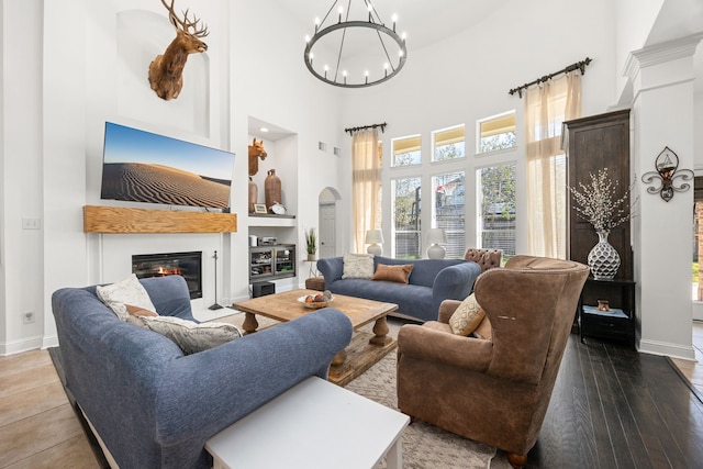 living room featuring hardwood / wood-style floors, a notable chandelier, and a high ceiling