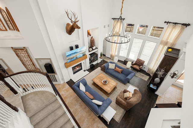 living room featuring tile patterned flooring, a towering ceiling, and a notable chandelier