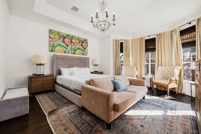 bedroom featuring a raised ceiling, crown molding, dark hardwood / wood-style flooring, and an inviting chandelier