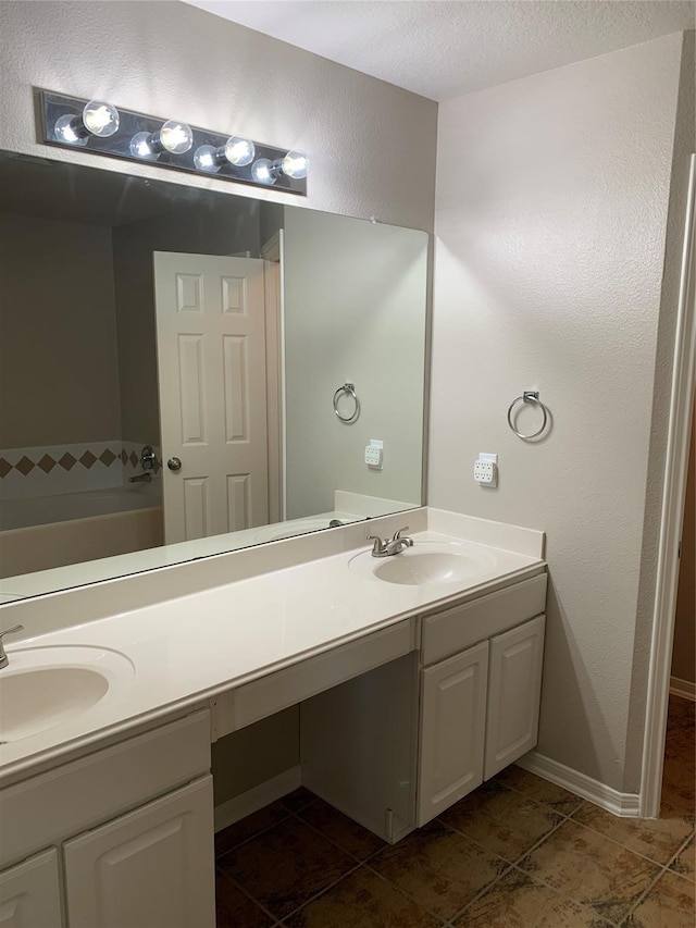 bathroom with a tub, tile patterned flooring, vanity, and a textured ceiling