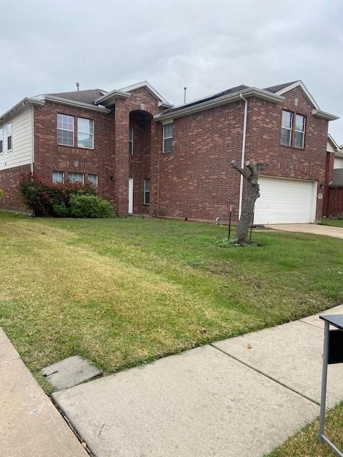 view of front of property with a garage and a front lawn