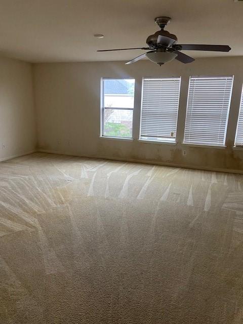 spare room featuring light carpet and ceiling fan