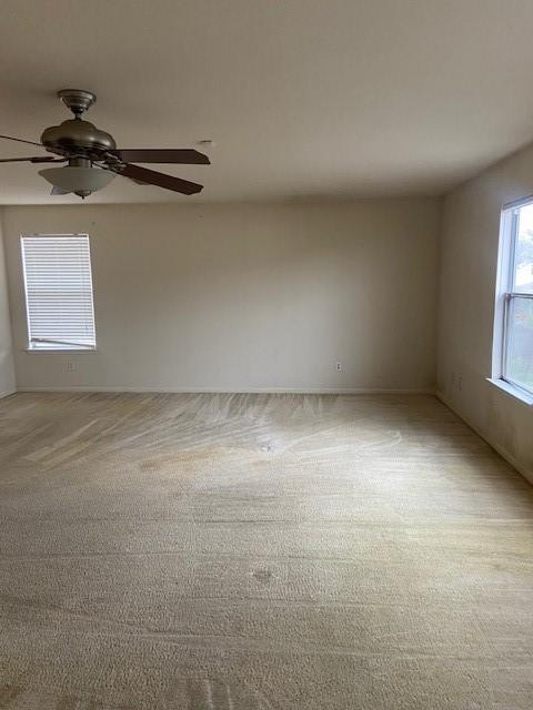 unfurnished room featuring light carpet and ceiling fan