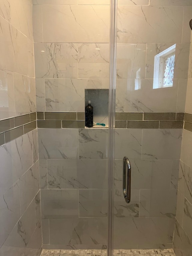 bathroom featuring a shower with door